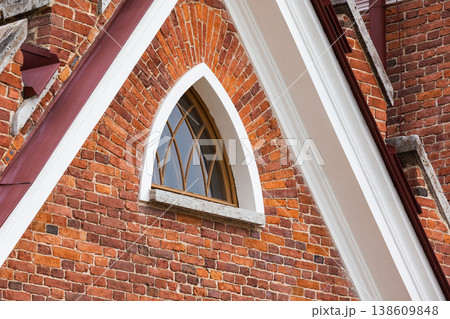 Historic red brick building features an arched wooden window 138609848