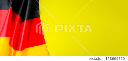 National symbol of Germany patriotic symbol on yellow background with place for text. German full framed wave Germany fabric flag. Copy space for your text. Independence 138609860