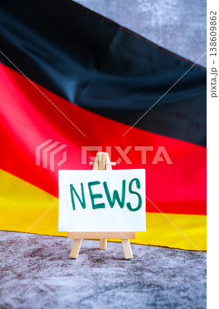 Paper note with words NEWS on National symbol of Germany. German wave silky flag background. News report headlines media Paper note with words NEWS on National symbol of Germany. German wave silky flag background. News report headlines media 138609862