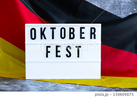 Lightbox with text OKTOBERFEST National symbol of Germany. German wave silky flag background. Traditional beer Bavarian festival. Travel to germany, visit munich european tourism German attractions 138609873