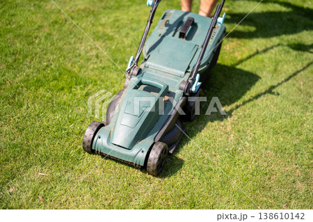 Lawn mowing in the garden, cutting green grass in the summer 138610142