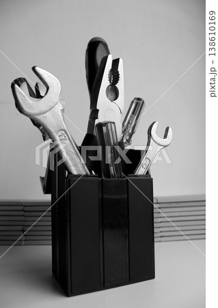 Bunch of carpentry tools in black plastic cup. Monochrome stock photo for workshop illustration Bunch of carpentry tools in black plastic cup. Monochrome stock photo for workshop illustration 138610169