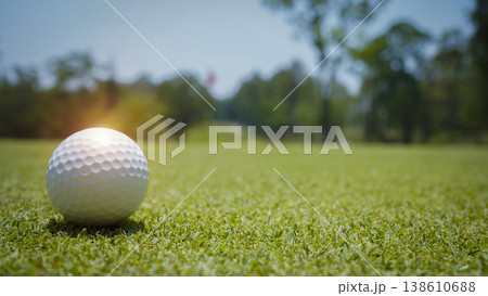 Golf ball is on a green lawn in a beautiful golf course with morning sunshine. Golf ball is on a green lawn in a beautiful golf course with morning sunshine. 138610688