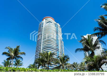 Skyscraper with palm tree. City architecture. Architecture of modern residential building. Perspective city skyscraper. Modern skyscraper building. Architectural building in Miami south beach Skyscraper with palm tree. City architecture. Architecture of modern residential building. Perspective city skyscraper. Modern skyscraper building. Architectural building in Miami south beach 138610799