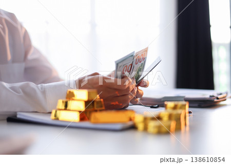 Businessman investing in gold. Strategy for businesspeople and institutional investors to diversify portfolios, hedge against inflation and currency depreciation, and act as a safe haven 138610854
