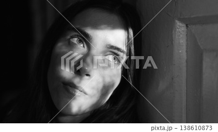 Black and white portrait of young woman with dramatic window light 138610873