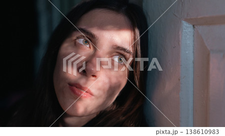 Young woman portrait with dramatic sunlight and shadow indoors 138610983
