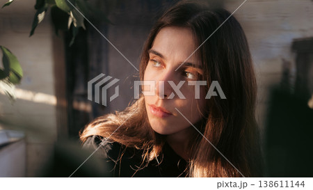 Natural outdoor portrait of thoughtful young woman in sunlight 138611144
