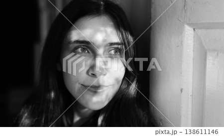 Black and white portrait of calm young woman by wall Black and white portrait of calm young woman by wall 138611146