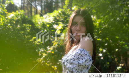 Young woman portrait in soft green forest light 138611244