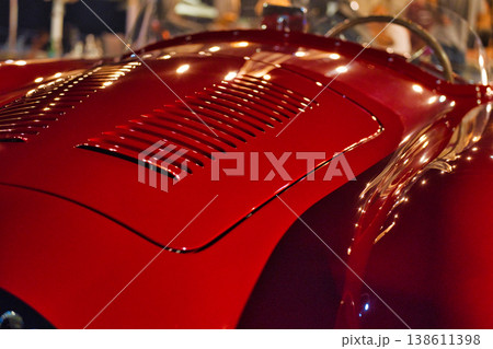 Close-up of vintage red car grille and headlights, classic automobile detail Close-up of vintage red car grille and headlights, classic automobile detail 138611398