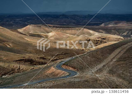 Dramatic desert landscape with mountains and storm clouds over arid valley Dramatic desert landscape with mountains and storm clouds over arid valley 138611456