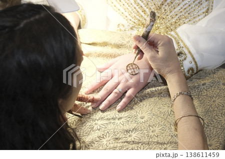 Moroccan henna tattoo on female hands during traditional celebration ceremony Moroccan henna tattoo on female hands during traditional celebration ceremony 138611459