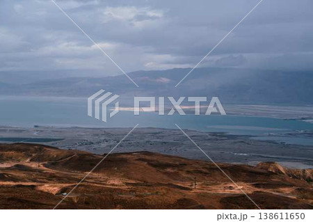 Dramatic desert coastline landscape with storm clouds over calm sea Dramatic desert coastline landscape with storm clouds over calm sea 138611650