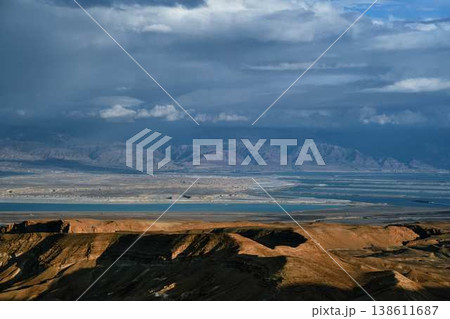 Dramatic desert coastline landscape with storm clouds over calm sea 138611687