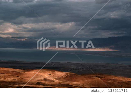 Dramatic desert coastline landscape with storm clouds over calm sea Dramatic desert coastline landscape with storm clouds over calm sea 138611711