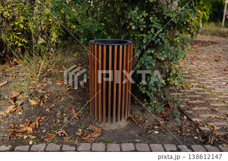 Empty park bench along paved pathway in green park 138612147