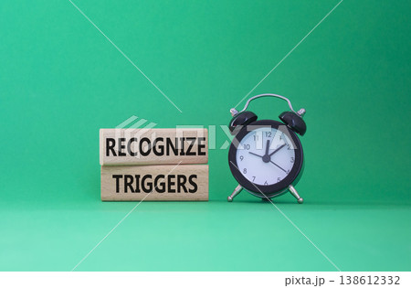 Recognize triggers symbol. Concept words Recognize triggers on wooden blocks. Beautiful green background with alarm clock. Business and Recognize triggers concept. Copy space. 138612332