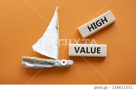 HIGH VALUE symbol. Concept word HIGH VALUE on wooden blocks. Beautiful orange background with boat. Business and HIGH VALUE concept. Copy space HIGH VALUE symbol. Concept word HIGH VALUE on wooden blocks. Beautiful orange background with boat. Business and HIGH VALUE concept. Copy space 138612551