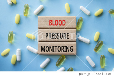 Blood Pressure Monitoring symbol. Concept words Blood Pressure Monitoring on wooden blocks. Beautiful blue background with pills. Healthcare and Blood Pressure Monitoring concept. Copy space. 138612556