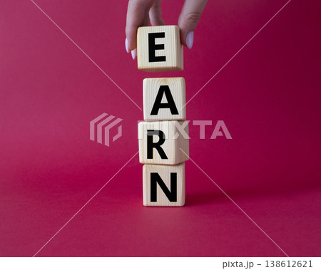 Earn symbol. Concept word Earn on wooden cubes. Businessman hand. Beautiful red background. Business and Earn concept. Copy space. 138612621
