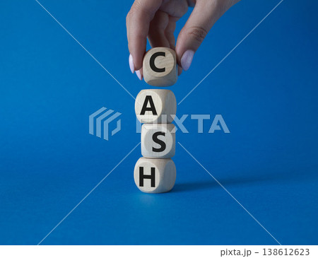 Cash symbol. Concept word Cash on wooden cubes. Beautiful blue background. Businessman hand. Business and Cash concept. Copy space. Cash symbol. Concept word Cash on wooden cubes. Beautiful blue background. Businessman hand. Business and Cash concept. Copy space. 138612623