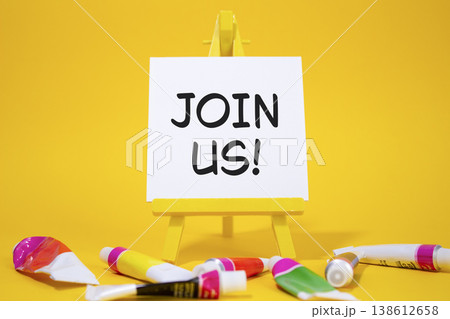 Join us symbol. Concept word Join us on wooden blocks. Beautiful yellow background with paints and easel. Business and Join us concept. Copy space Join us symbol. Concept word Join us on wooden blocks. Beautiful yellow background with paints and easel. Business and Join us concept. Copy space 138612658