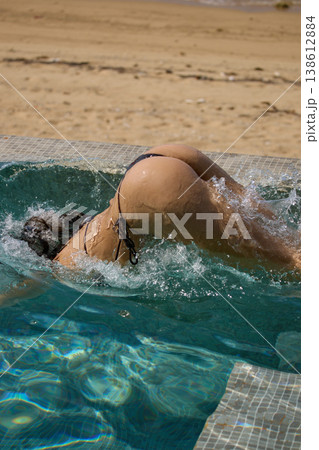 a girl with a beautiful tanned body having fun in the swimming pool of a luxury villa, the girl's butt is visible from under the water, azure water, splashes of water glow in the sun a girl with a beautiful tanned body having fun in the swimming pool of a luxury villa, the girl's butt is visible from under the water, azure water, splashes of water glow in the sun 138612884