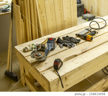 The image shows a woodworking workshop scene with raw lumber pieces scattered on a workbench covered in sawdust, showcasing the process of constructing a mortise and tenon joint. The image shows a woodworking workshop scene with raw lumber pieces scattered on a workbench covered in sawdust, showcasing the process of constructing a mortise and tenon joint. 138613056