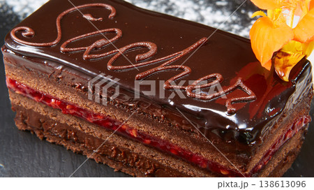 Sachertorte slice featuring rich chocolate ganache, apricot jam layers, and elegant calligraphy Sachertorte slice featuring rich chocolate ganache, apricot jam layers, and elegant calligraphy 138613096