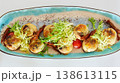 A multi-sensory gourmet appetizer featuring seared scallops with melted cheese 138613115