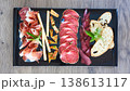 A multi-sensory charcuterie board featuring premium sliced salami, prosciutto 138613117