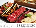 A multi-sensory charcuterie board featuring premium sliced salami, prosciutto 138613120