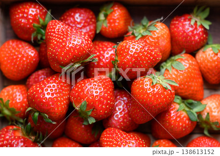 Close up of sweet ripe strawberries with green tops Close up of sweet ripe strawberries with green tops 138613152