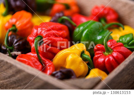 Close view of mixed habanero peppers inside wooden crate Close view of mixed habanero peppers inside wooden crate 138613153