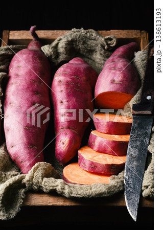 Sweet potato on rustic wooden box with knife and slices 138613193
