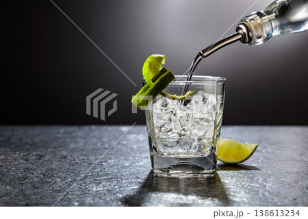 Vodka with lime and ice cubes in a fogged up glass. Vodka with lime and ice cubes in a fogged up glass. 138613234