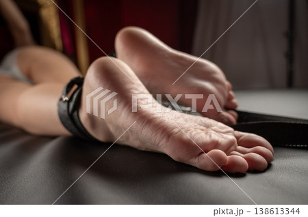 Women's legs in leather shackles. BDSM fetish. 138613344