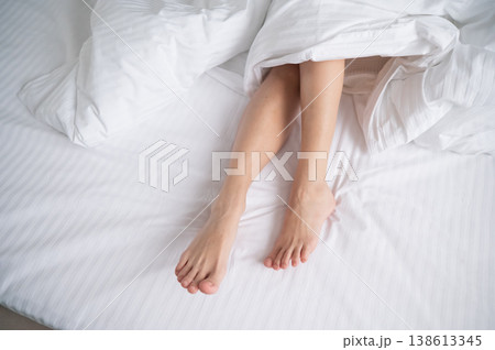 Foot fetish. Bare female feet protruding from under the blanket. 138613345