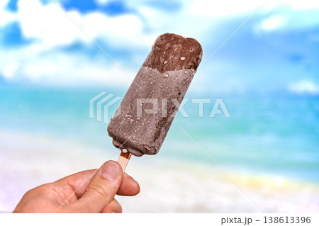 Chocolate Ice Cream Bar on a Stick with Tropical Beach Background 138613396
