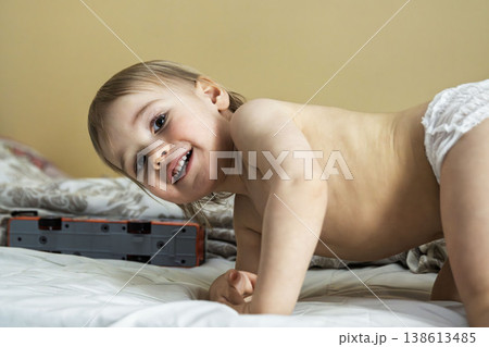 Happy toddler playing on bed at home, candid childhood moment Happy toddler playing on bed at home, candid childhood moment 138613485