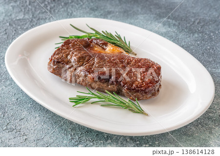Perfectly grilled beef steak with rosemary on white plate premium restaurant presentation 138614128