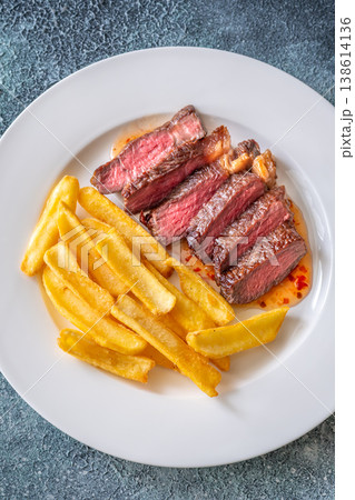 Sliced grilled beef steak with fries and chili sauce gourmet meal top view 138614136