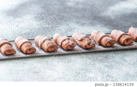 Chocolate croissants dusted with sugar on slate platter bakery top view composition Chocolate croissants dusted with sugar on slate platter bakery top view composition 138614139
