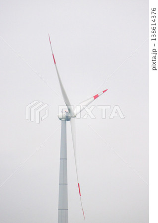wind turbines in field rotate their blades to generate energy. windmill on spacious green field. wind turbines in field rotate their blades to generate energy. windmill on spacious green field. 138614376
