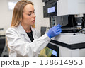 A technician calibrating an automated high performance liquid chromatography HPLC instrument at a clinical testing facility. 138614953