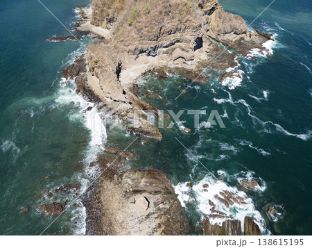 Coastline with rocky shore, clear water, and waves crashing in sunlight Coastline with rocky shore, clear water, and waves crashing in sunlight 138615195