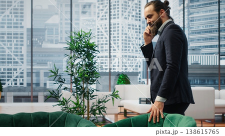 CEO multitasking and managing an important phone call with investors while he reviews financial reports on his laptop. Strategic decision making in corporate life at the workplace. Camera B. CEO multitasking and managing an important phone call with investors while he reviews financial reports on his laptop. Strategic decision making in corporate life at the workplace. Camera B. 138615765