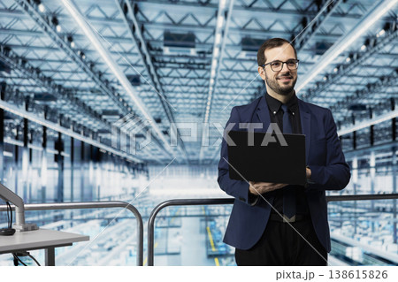 Manage resource allocation, microchip and portrait of smiling man using laptop in factory. Analyzing industry 4.0 plant operations efficiency, semiconductors and happy director on elevated platform 138615826