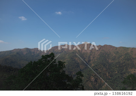 Mountain ridge landscape under clear blue sky, scenic highland terrain with forested slopes and rugged peaks in natural daylight. Mountain ridge landscape under clear blue sky, scenic highland terrain with forested slopes and rugged peaks in natural daylight. 138616192